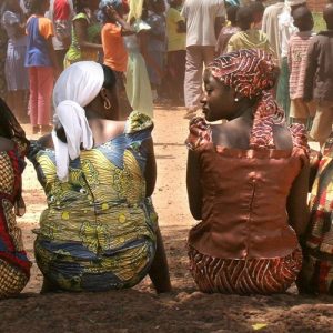 Zwei Frauen sitzen nebeneinander und schauen sich an